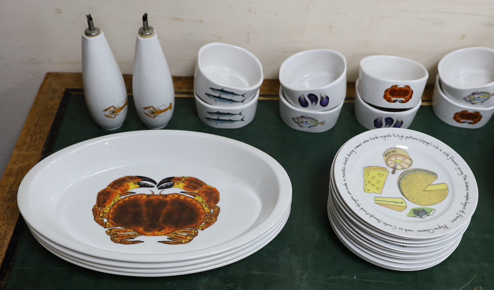 An extensive Richard Bramble for Jersey Pottery dinner service, decorated with fish, cheese etc.